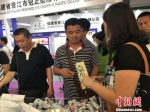 7月27日，首届海峡两岸食品交易会暨第四届闽台(泉州)食品交易会(以下简称“食交会”)在中国品牌之都——福建晋江举办。图为食客品尝休闲化的传统食品。　刘真真 摄 - 台湾新闻-中国新闻网