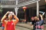 图为台湾客家青年在福建永定客家土楼内转一圈360度拍土楼。　张金川 摄 - 台湾新闻-中国新闻网
