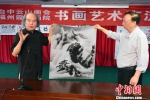 跨海前来参加书画艺术笔会交流活动的台中云山画会艺术总监、台湾著名水墨大师葛宪能(左)为福州市霞光画院院长张天金(右)介绍其现场创作画作的艺术构思。　记者刘可耕 摄 - 台湾新闻-中国新闻网